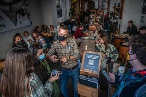 Un grupo de clientes muestra el pasaporte covid para acceder a un restaurante de Barcelona