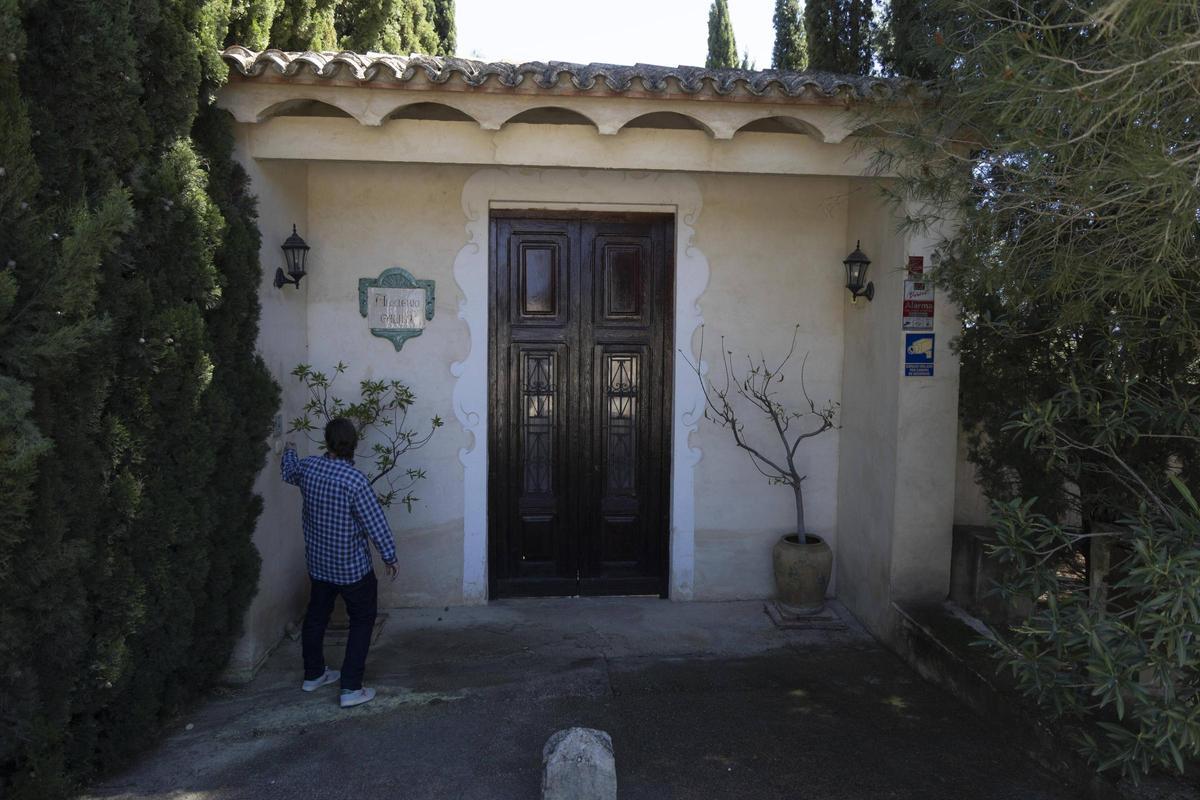 Un hombre llama al timbre de la puerta principal de la Alquería de Galim, ayer.