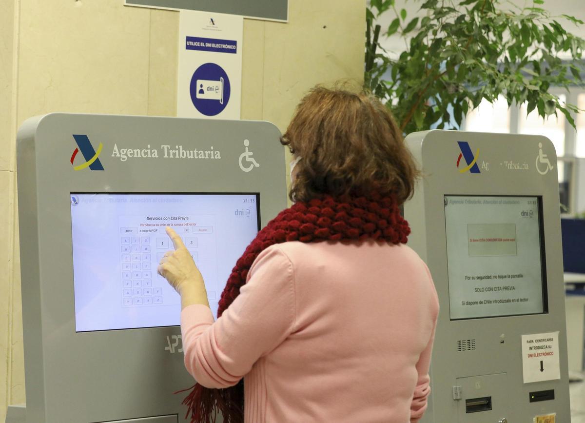 Una mujer pide cita previa en una sede de la Agencia Tributaria.