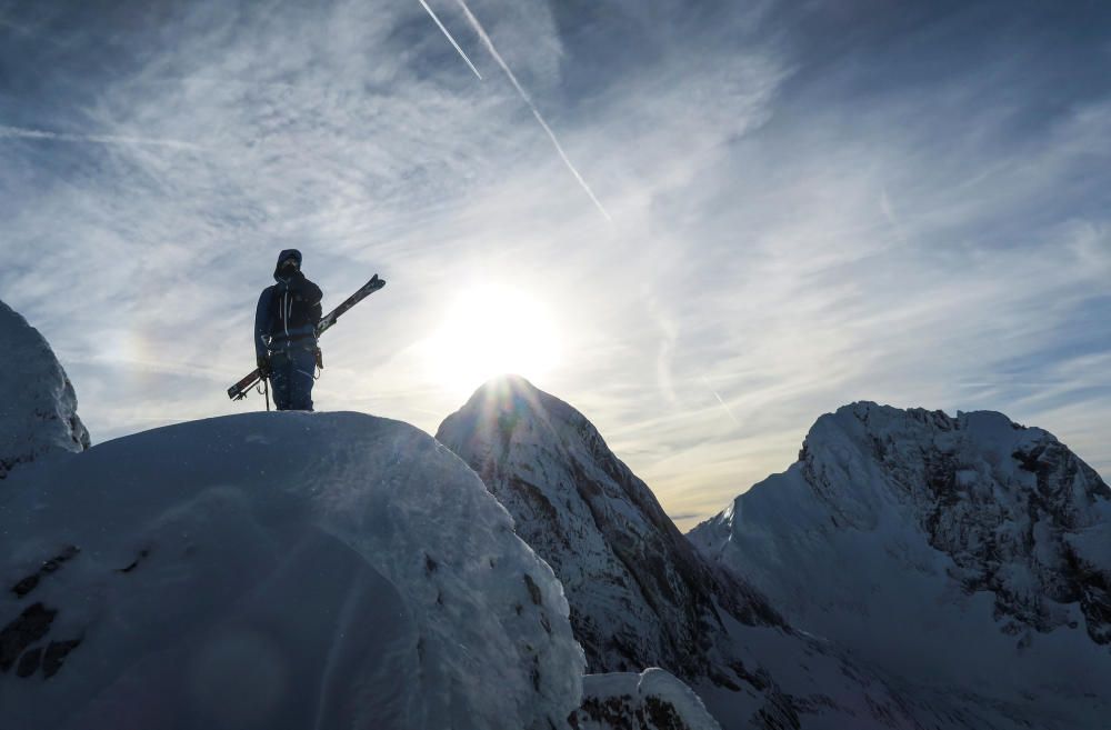 A skier stands on the summit of the Dachstein ...