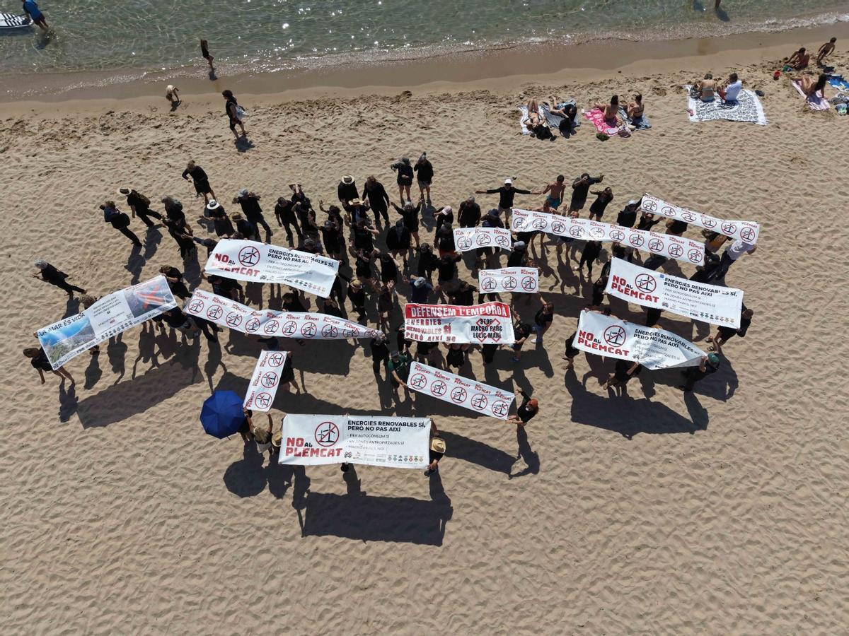 Pancarta i participants en la manifestació en contra de l'eòlica marina a cala Montgo el 31 de maig.