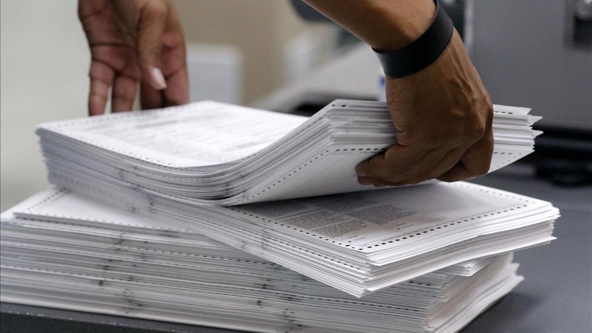 Un miembro del personal electoral carga sufragios en la Oficina del Supervisor Electoral del Condado de Broward, en Florida.