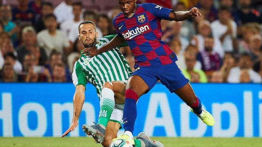 Ansu Fati trata de escapar de la entrada de un jugador del Betis. // Efe