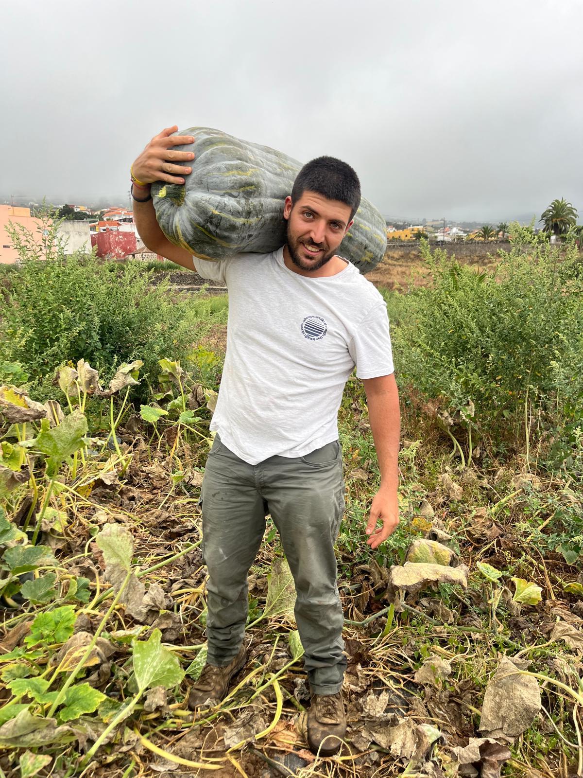 Benjamín Farrais, con una calabaza en los brazos cultivada en su finca de Tenerife.