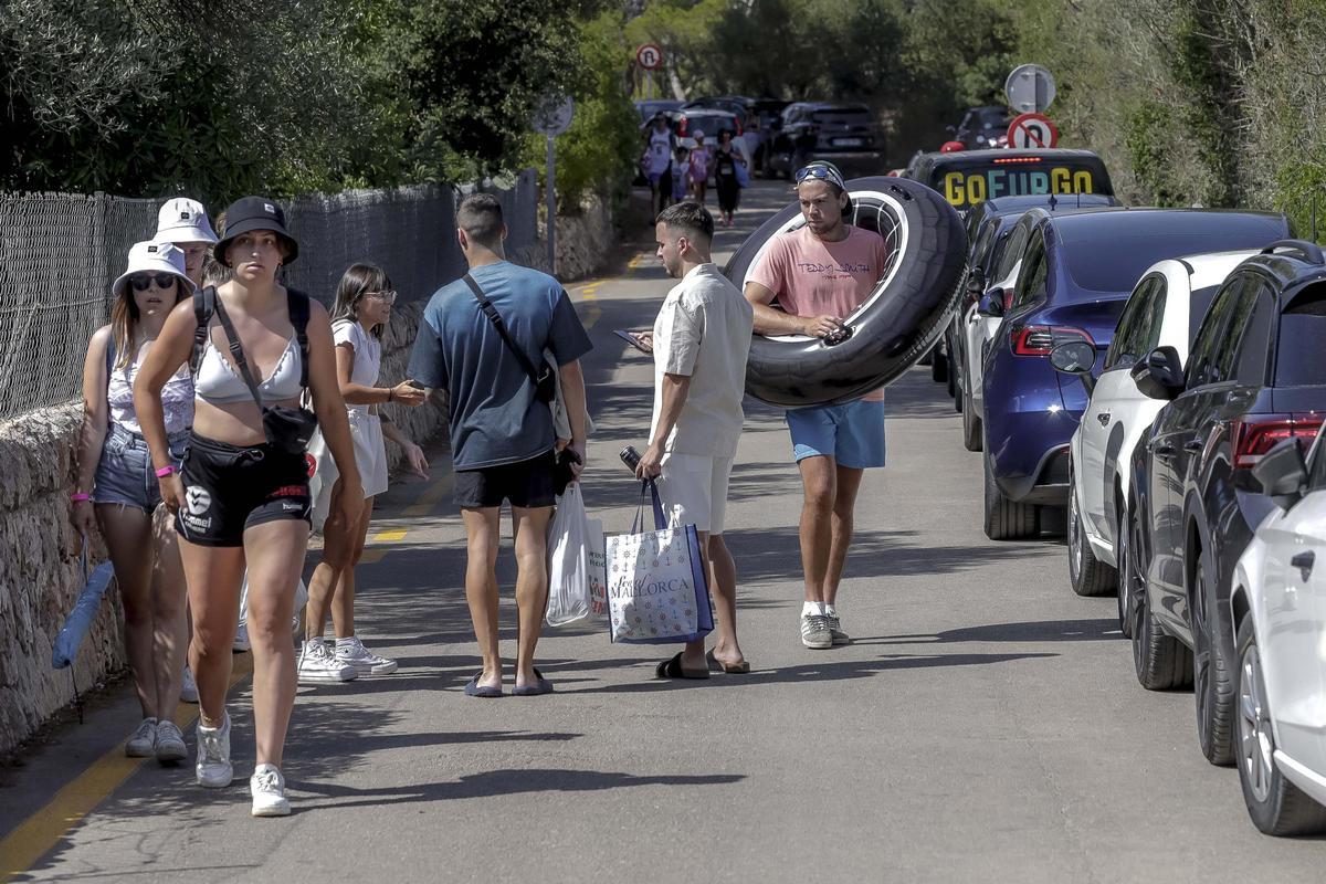 Bañistas regresan de la playa cargados con los útiles indispensables.