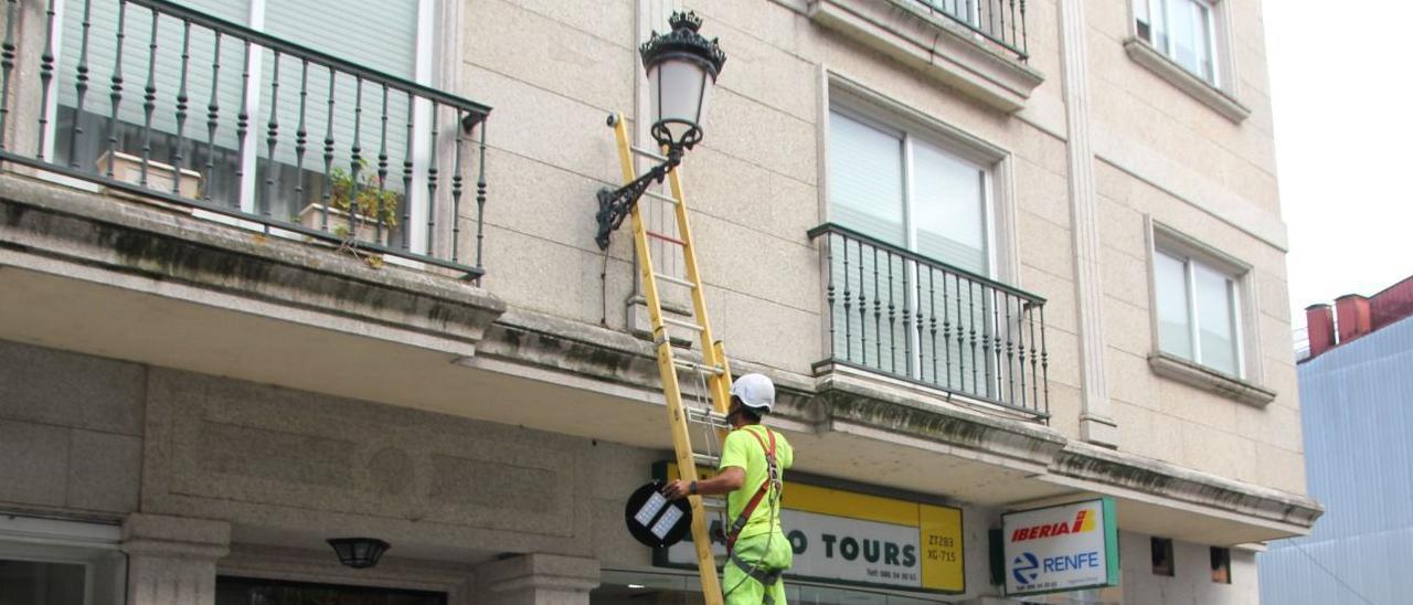 Un operario cambia las bombillas a tecnología LED. // D.P.