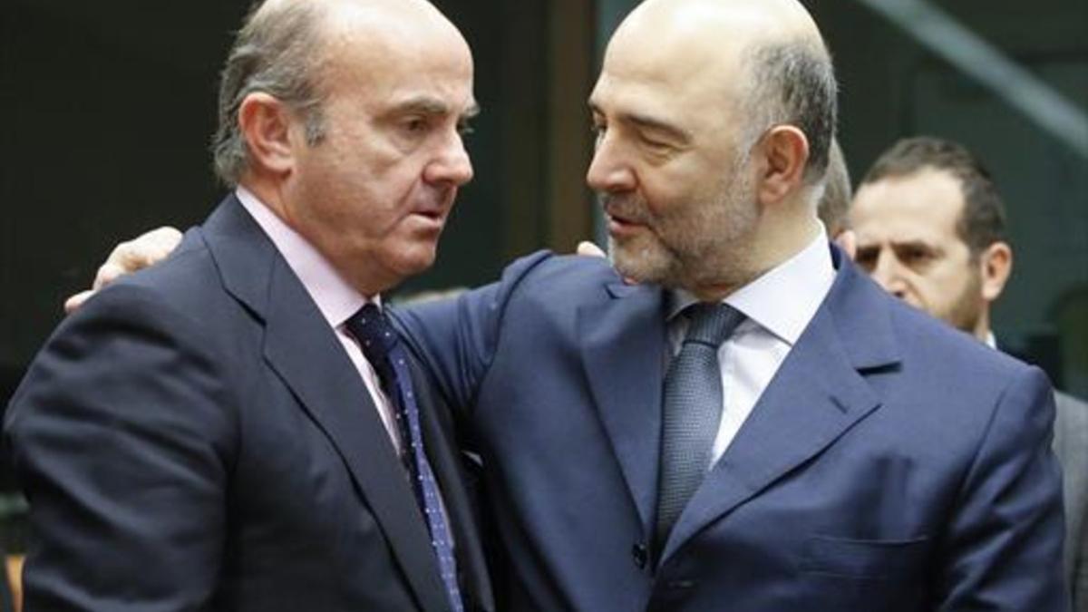 Luis de Guindos y el comisario europeo de Asuntos Económicos, Pierre Moscovici, ayer, en Bruselas.