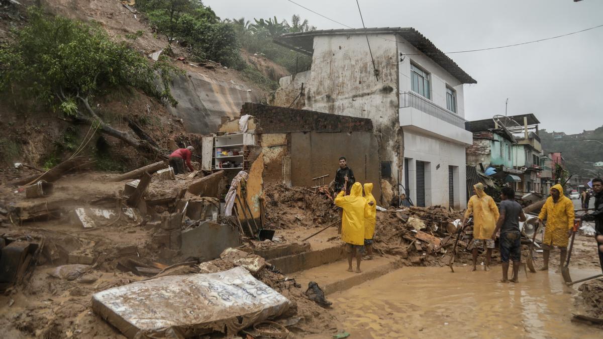 Varias personas frente a los restos de una casa que se derrumbó durante un deslizamiento de tierra por las fuertes lluvias en Recife (Brasil) el 28 de mayo de 2022