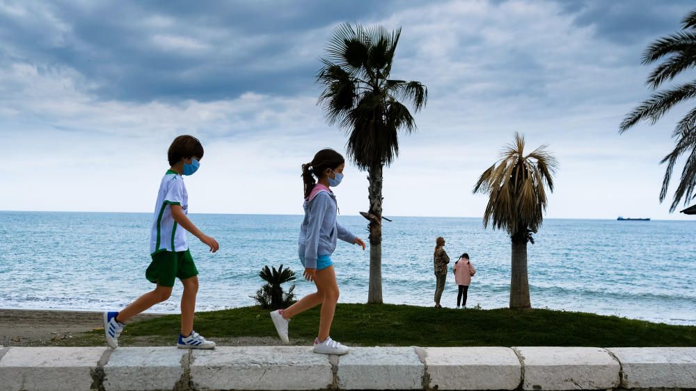 Padres e hijos aprovechan el primer día del desconfinamiento parcial de los niños menores de 14 años para dar un paseo por calles y plazas del Centro de Málaga. En la playa, algunos pequeños aprovechaban para remojarse los pies, bordeando una de las prohibiciones de esta nueva medida.