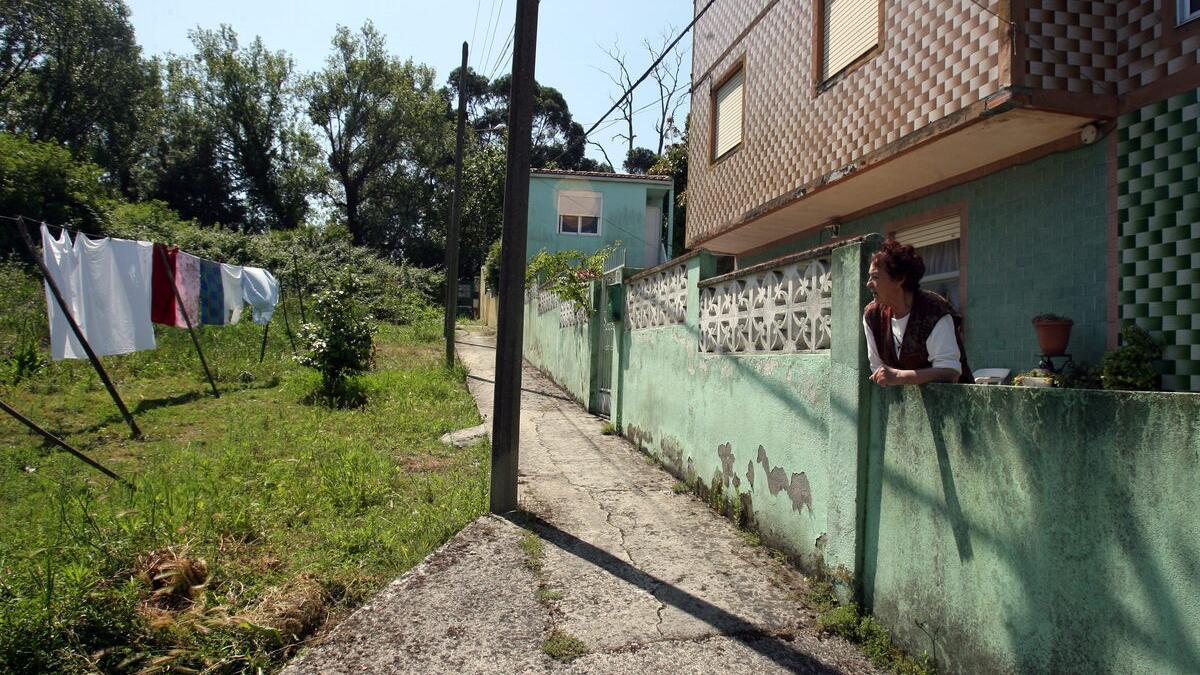 Imagen de archivo de una mujer con la ropa tendida ante su vivienda