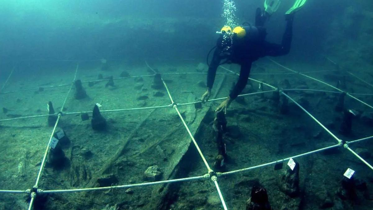 Un arqueólogo recupera una canoa prehistórica hallada a las orillas del poblado neolítico de La Marmotta.