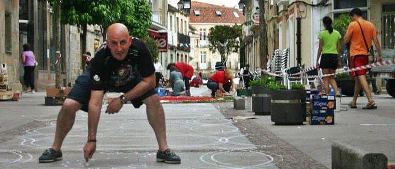 Carlos Henrique Fernández Coto, dibujando motivos de alfombras florales en una calle de Rianxo.