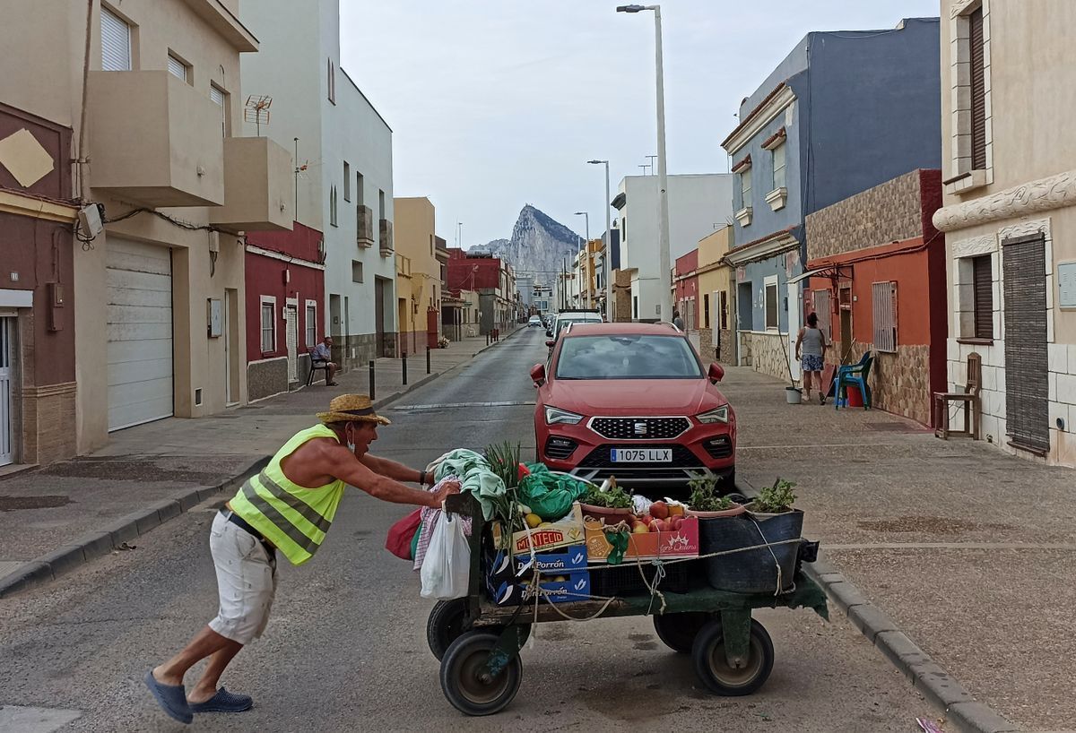 Un hombre con el carro con el que vende macetas y fruta en el barrio La Atunara de La Línea.