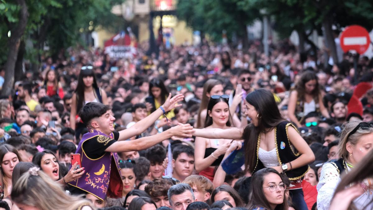 Una pareja de jóvenes festeros se reencuentra en la multitudinaria Entrada de Bandas.