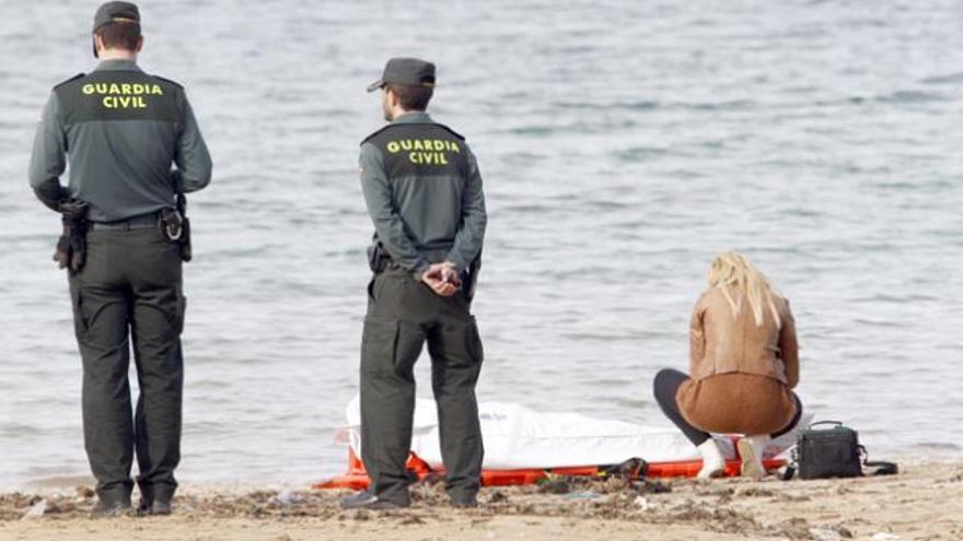 Una especialista de la Guardia Civil examina el cadáver, ayer en la playa de s´Arenal.
