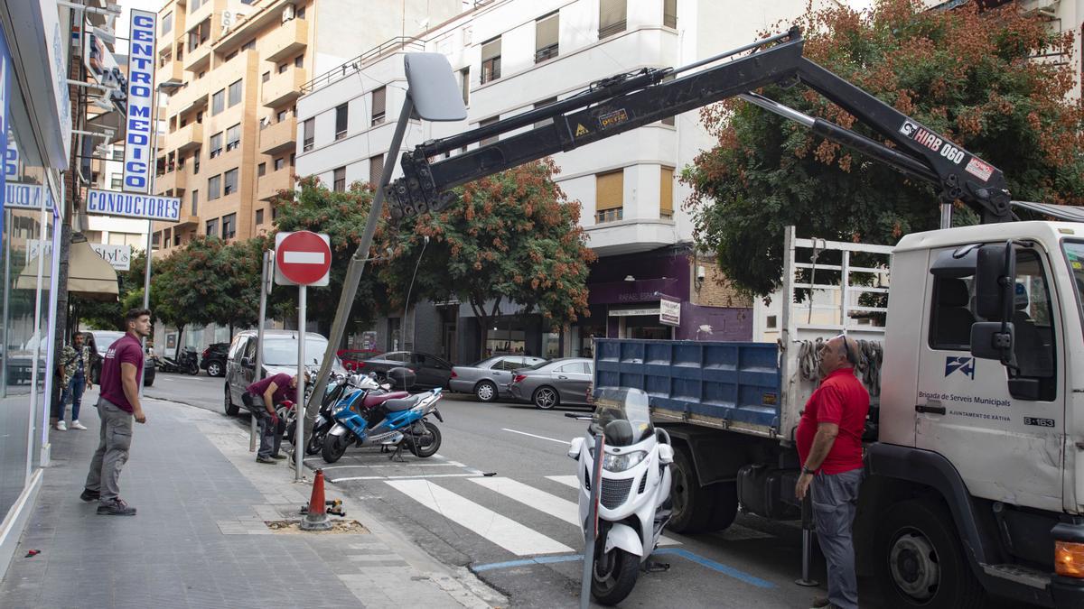 Retirada de una farola oxidada por el orín de los perros, en la calle República Argentina