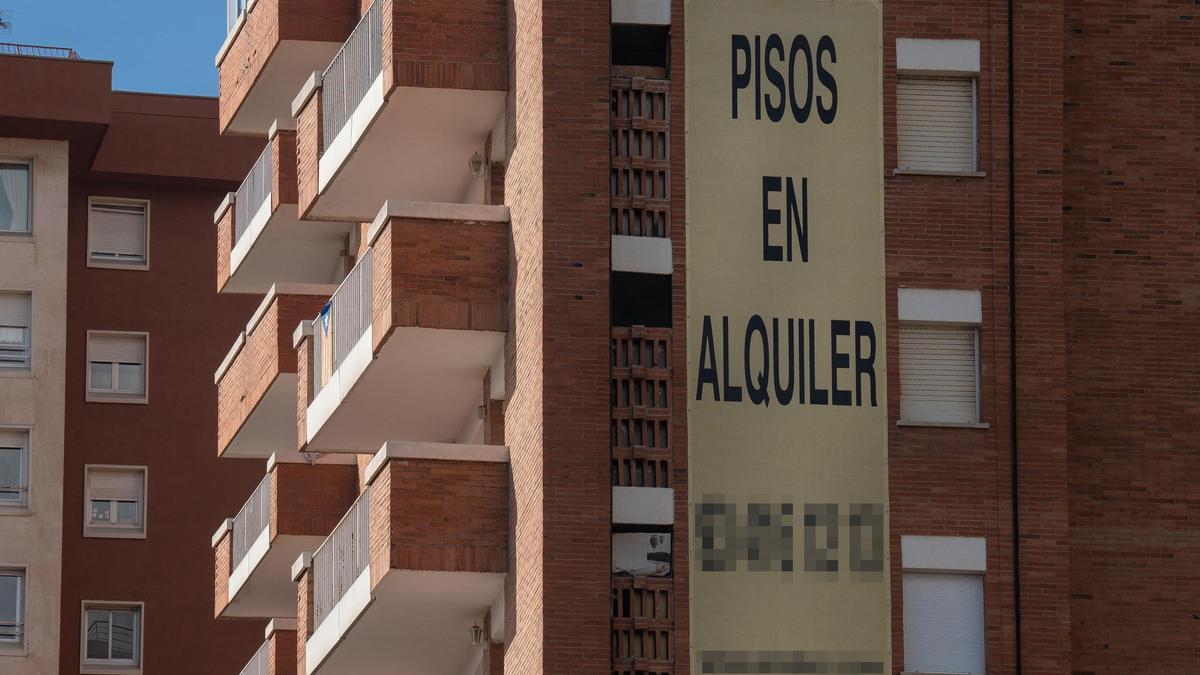 Cartel de alquiler de viviendas en la fachada de un edificio.