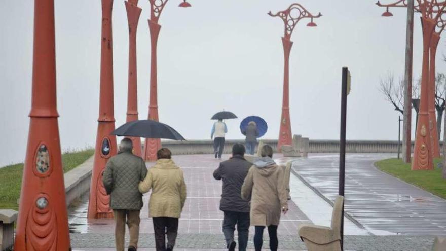 Viandantes pasean con paraguas un día de lluvia en A Coruña.