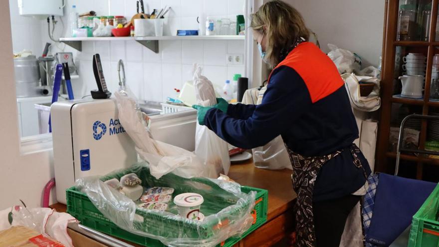 Una voluntaria prepara una bolsa de alimentos.