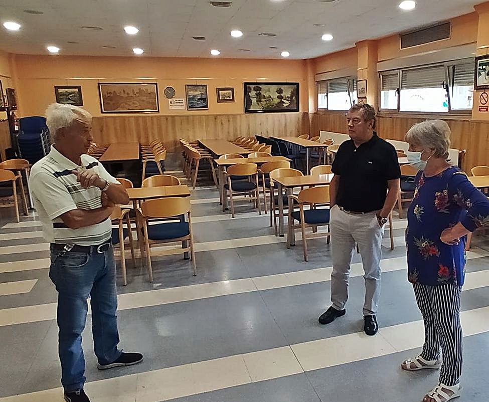 Por la izquierda, José Ramón Suárez, Rafael Martínez y María del Carmen Costoya, en el salón de actos del hogar del jubilado de Rioturbio, listo para retomar la actividad.   