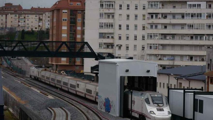 Un tren comercial, en el cambiador de ancho, ayer. Detrás, el bloque de pisos afectado.