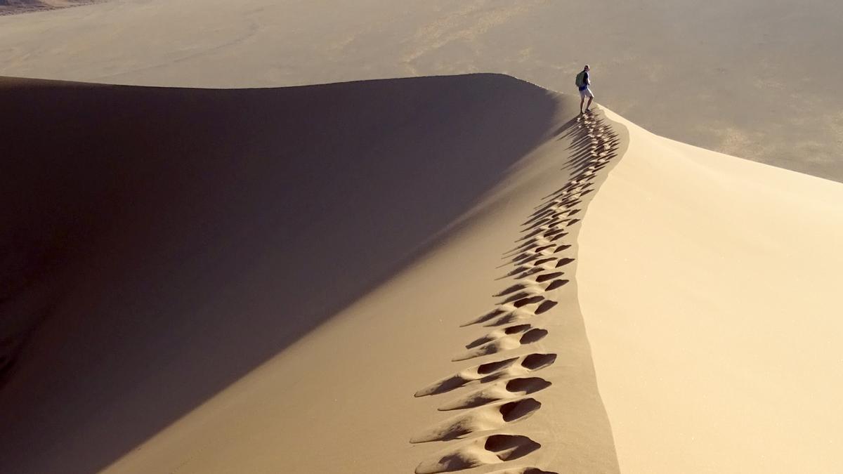 Un hombre camina por el desierto.