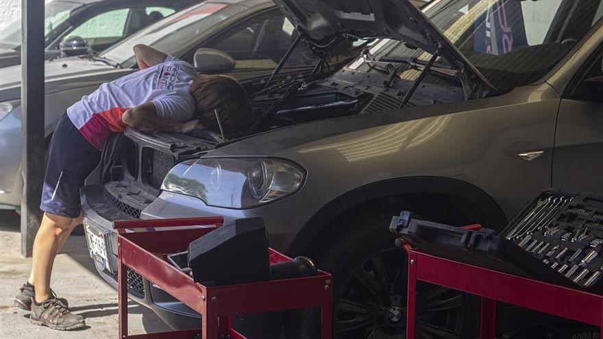 Una mujer revisa el motor de su coche