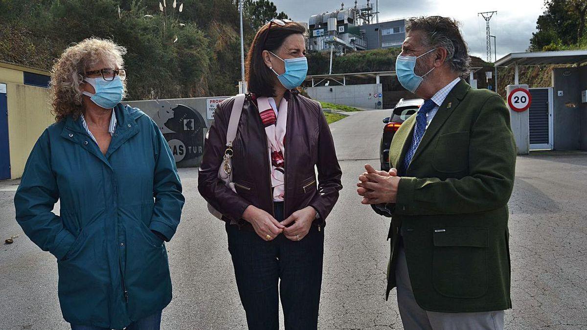 La concejala de Obras del Ayuntamiento de Navia, Mari Cruz Fernández; Nieves Roqueñí e Ignacio García Palacios, ayer, con la planta de purines al fondo.