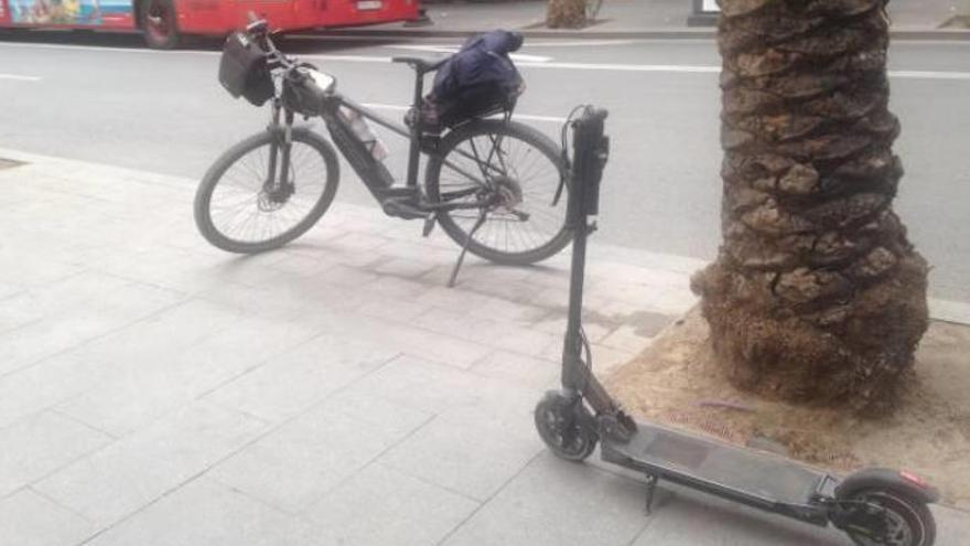 La bicicleta de uno de los policías locales y el patinete sancionado el pasado abril en una calle de Alicante