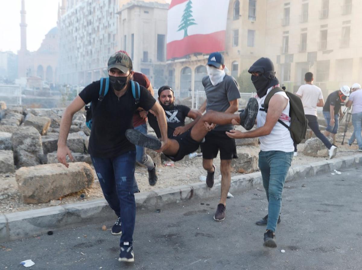 Demonstrators carry an injured man during a protest in Beirut, Lebanon, August 8, 2020. REUTERS/Goran Tomasevic