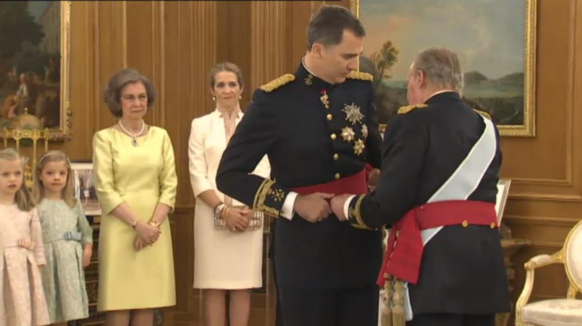 Juan Carlos I le pone el fajín al nuevo Rey, Felipe VI, en el Palacio de la Zarzuela