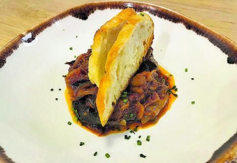 Rosbif con rúcula, cherrys confitados,
pepinillos y salsa tártara. Bajo, hamburguesa de pulpo.