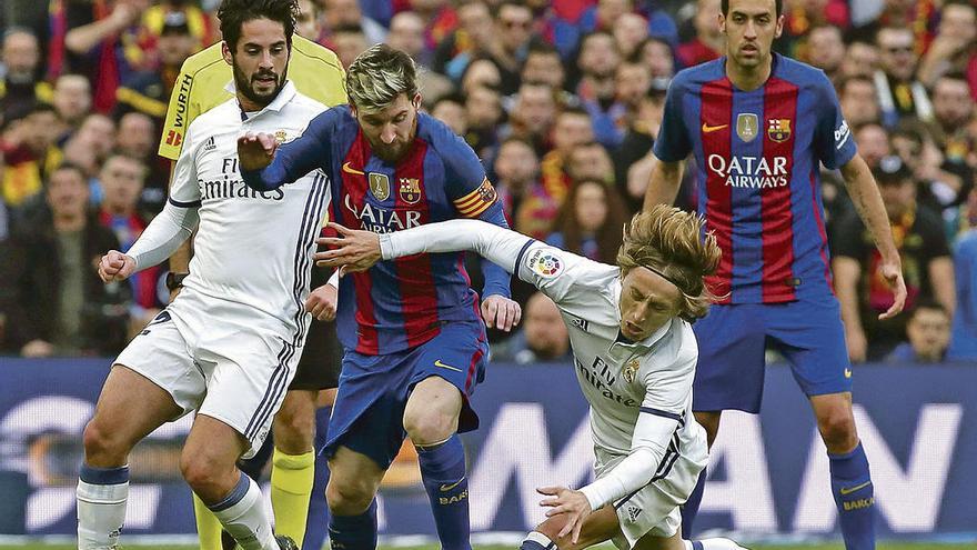 Modric se lanza al suelo para cortar un avance de Messi, con Isco y Busquets detrás.