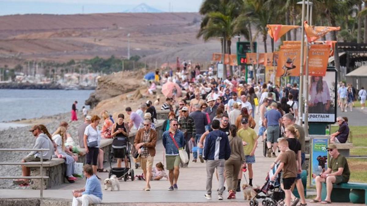 Turistas pasean por las inmediaciones del Faro de Maspalomas.
