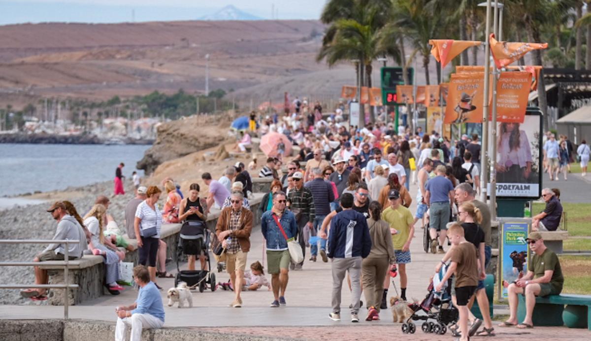 Turistas pasean por las inmediaciones del Faro de Maspalomas.