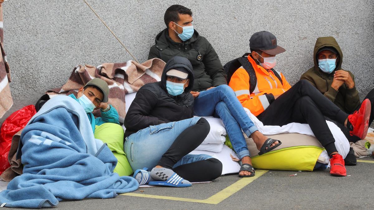 Migrantes pernoctando fuera de un campamento.