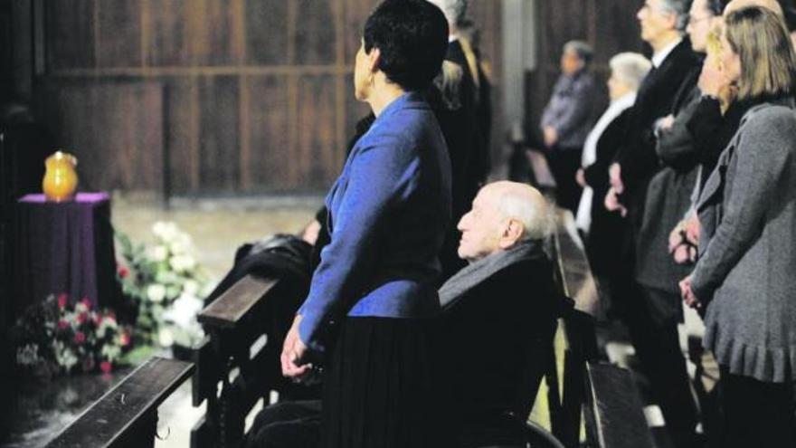 El poeta Carlos Bousoño, en silla de ruedas, detrás de su esposa Ruth Crespo, durante el funeral por su hermano.