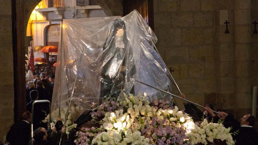Pasos del Prendimiento, la Virgen de la Soledad y el Cristo del Espíritu Santo protegidos con plásticos en desfiles procesionales de hace años en los que llovió. | |  ARCHIVO