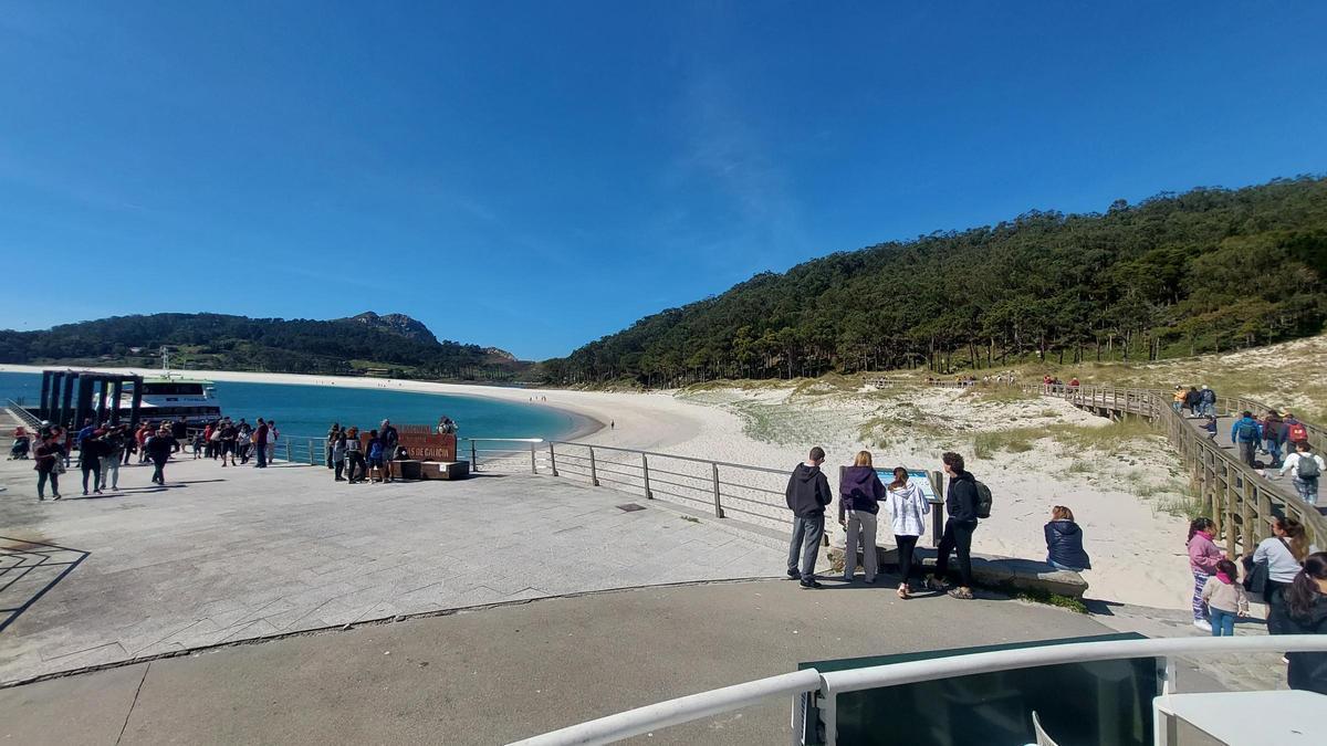 Viajeros llegando al muelle de las Islas Cíes, pegado a la famosa playa de Rodas.