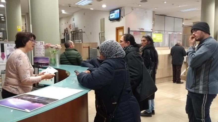 Varios vecinos esperando, en la oficina de atención al ciudadano de Camí Reial.