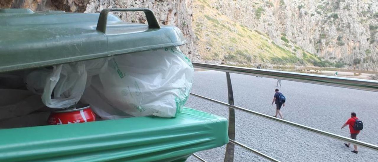 Un contenedor de basura, repleto en la entrada del Torrent de Pareis.