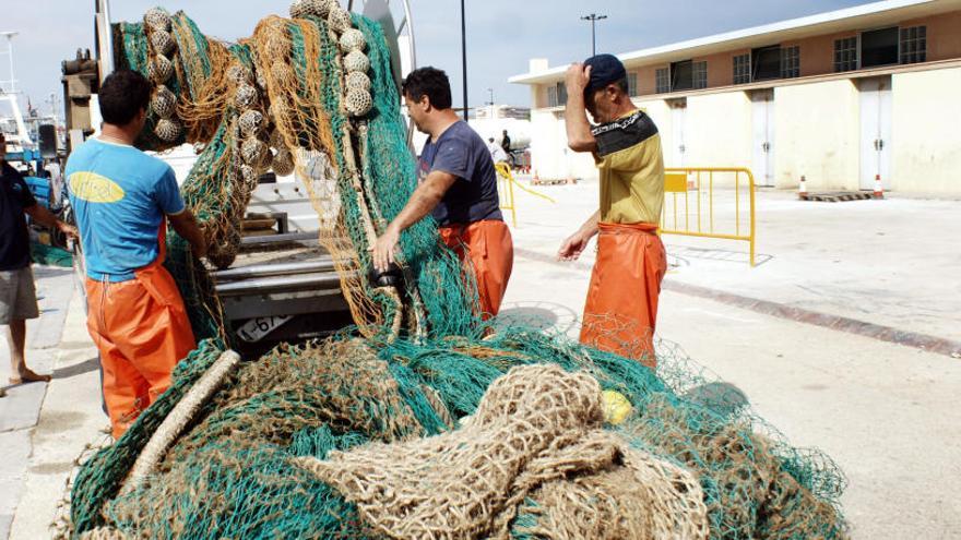 Pescadores preparándose en el muelle para una jornada en alta mar, en imagen de archivo.