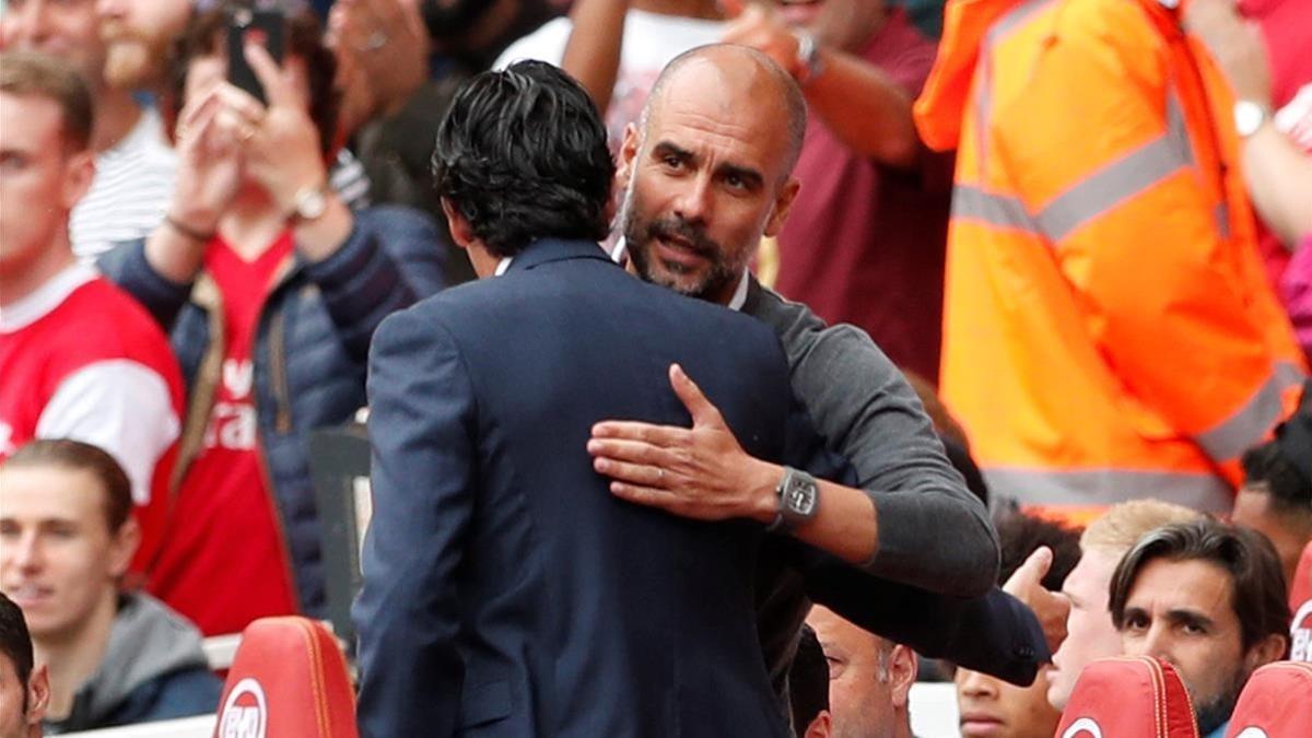 Pep Guardiola y Unai Emery (de espaldas) se saludan antes del Arsenal-Manchester City.