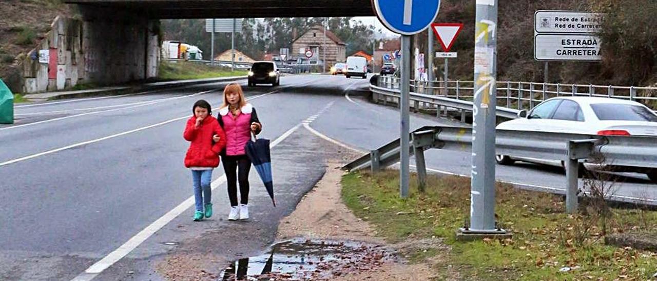 Zona de Ameirolongo, en la N-550, sin tramo de acera y sin paso de peatones para cruzar una salida de la A-52. |   // A.H.