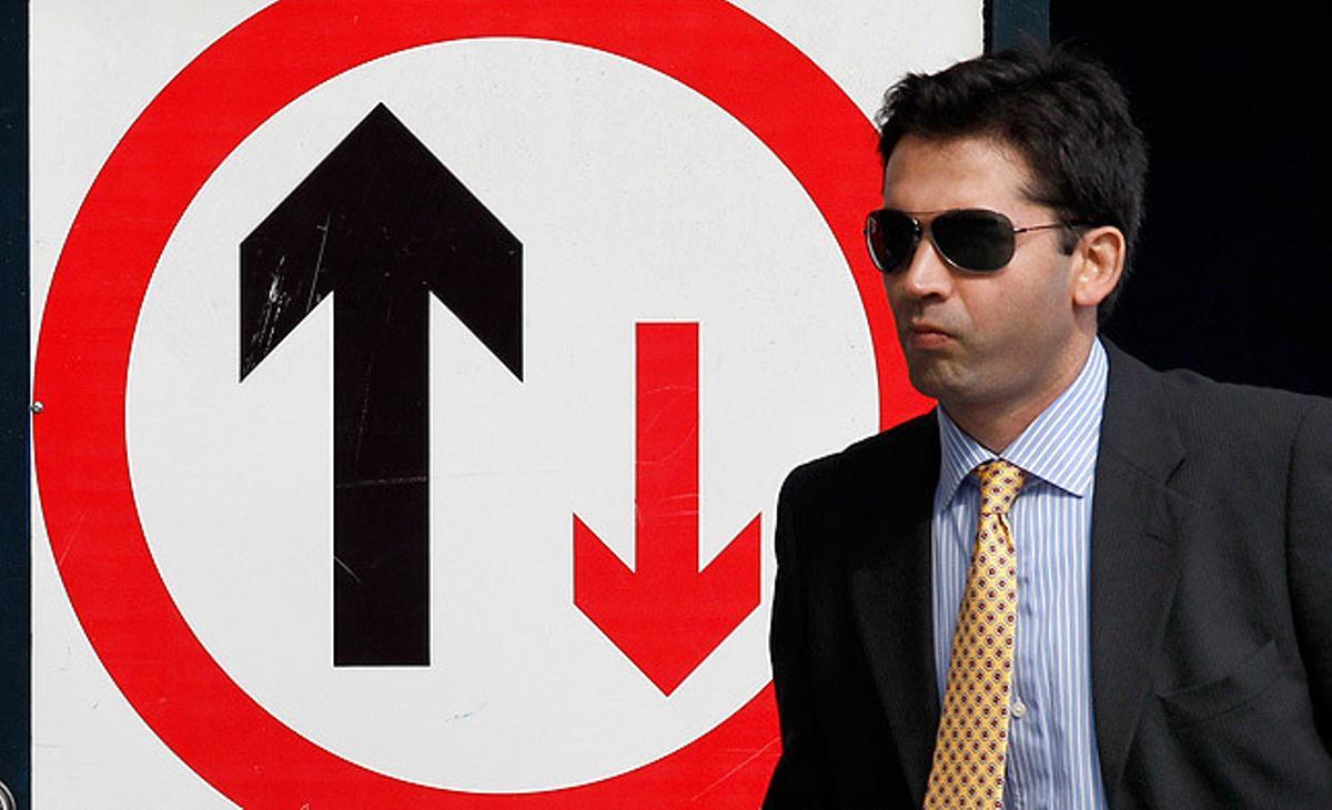 Un home de negocis passa davant d’un senyal en un carrer en obres al districte financer de Londres.