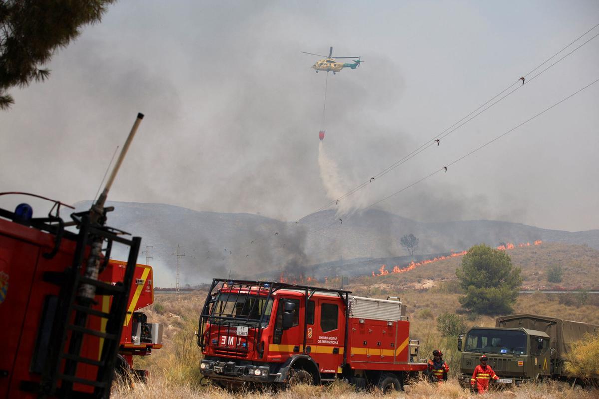 Miembros de la UME (unidad militar de emergencia española) trabajan como helicóptero vierte agua durante un incendio forestal en Los Gallardos, Almería, España, el 10 de julio de 2026.