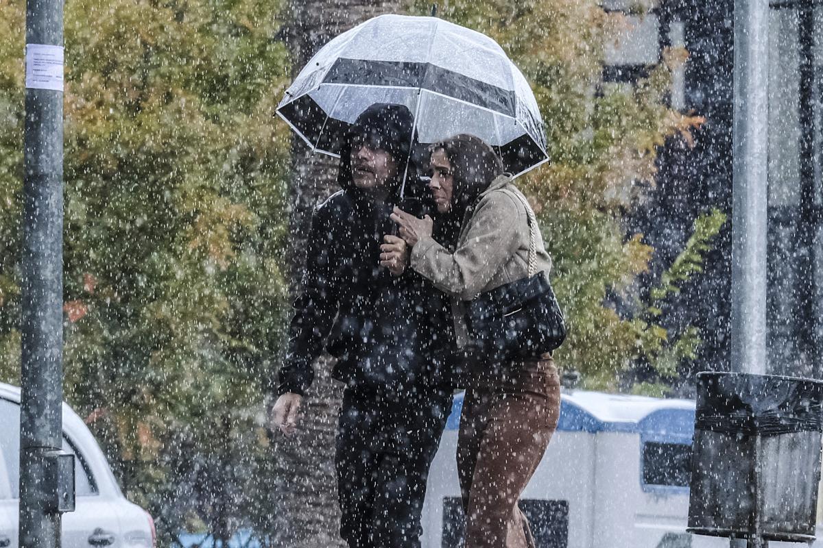 Dos personas se refugian de la lluvia bajo un paraguas en Agüimes
