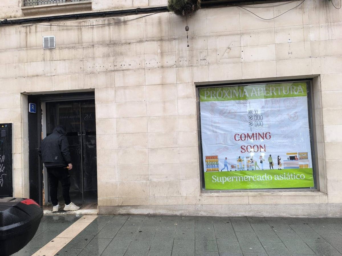 Fachada del local por la parte de la Calle San Miguel, mientras un operario trabaja en la puerta