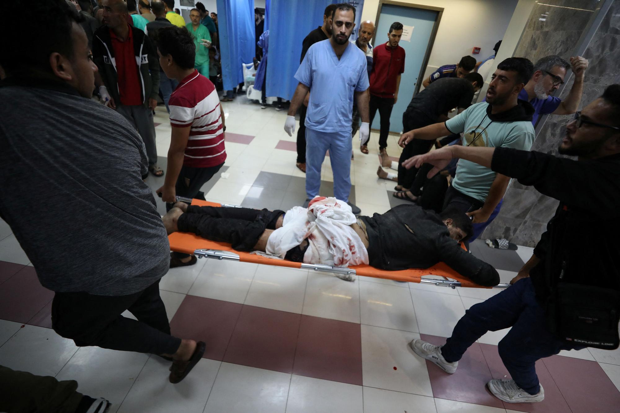 Injured people are assisted after Israeli air strike hit a hospital, according to Gaza Health Ministry