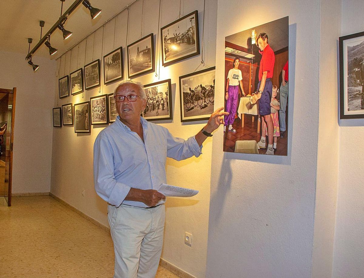 Santiago García muestra una de las fotografías de la muestra de Pola de Lena, en la que “El Tarangu” escancia un culete de sidra. | Roberto Menéndez